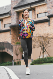 a woman running down a street in front of a building